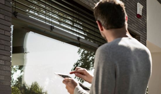 Mann bedient per App seinen Rollladen