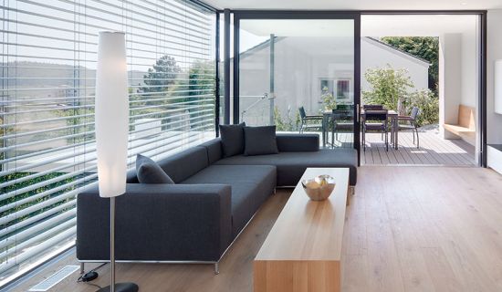 Wohnzimmer, das mit aufgerollter Jalousie beschattet wird