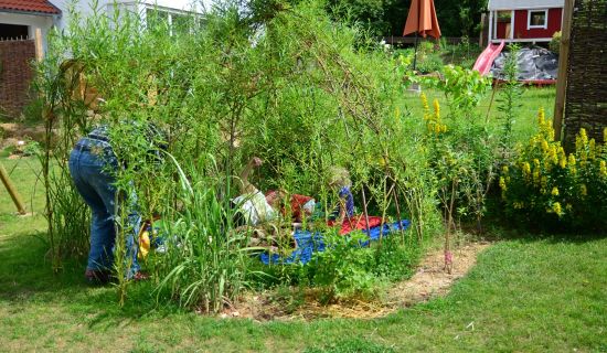 Begrüntes Weidentipi mit Kind und Eltern im Tipi