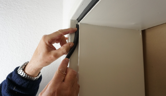 Eine Person drückt eine Fensterdichtung in die Nut