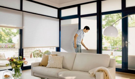 Mann zieht Plissees hoch