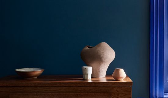 Stilleben mit blauer Wand und rosa Dekoobjekten