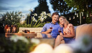 Glückliches Paar trinkt Wein im Garten