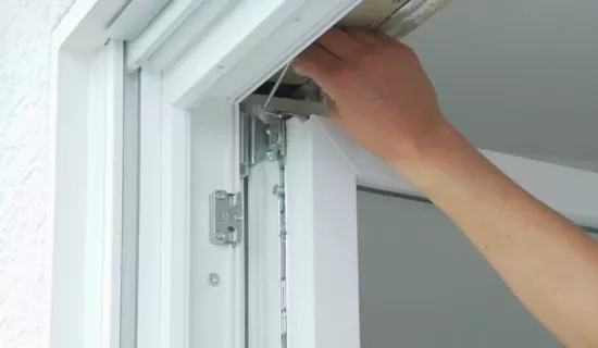 Ein Fenster wird am oberen Scherenlager justiert.