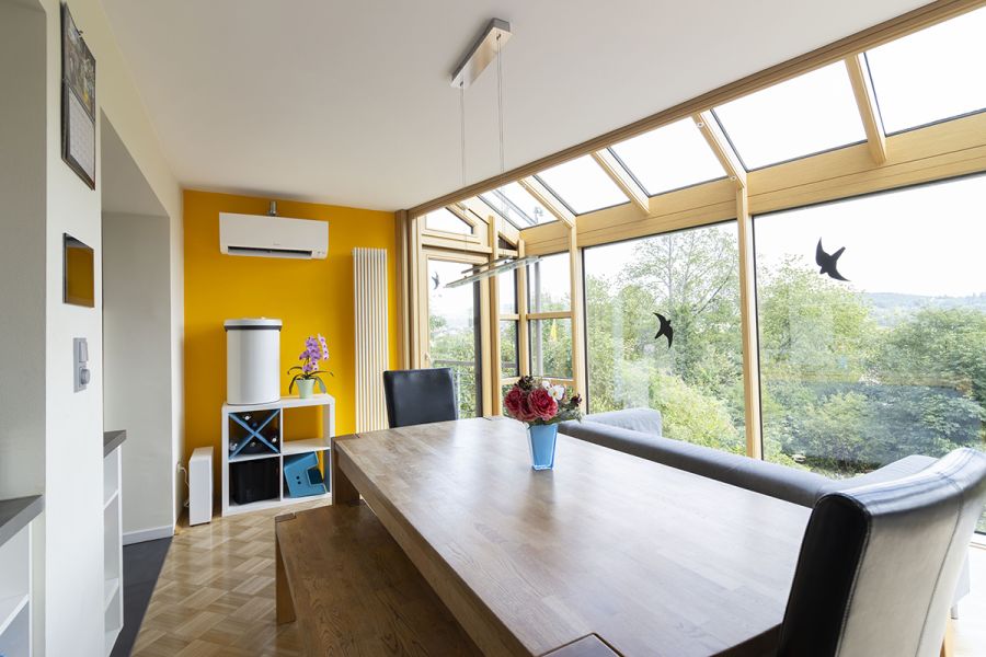 Große Fensterfronten in einem Esszimmer, darin ist eine Klimaanlage installiert