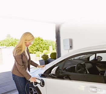 Frau lädt E-Auto an der Wallbox