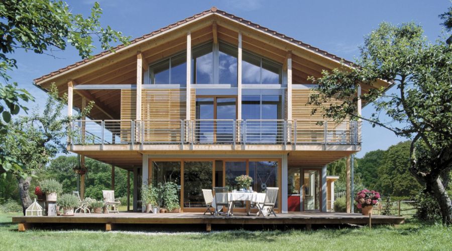 Modernes Holzhaus mit großen Fenstern und Garten