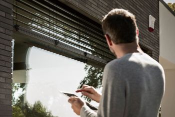 Mann bedient per App seinen Rollladen