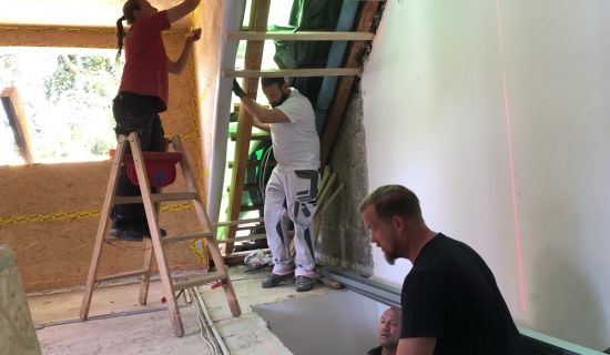 Verschiedene Handwerker arbeiten gleichzeitig im Dachgeschoss