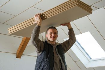 Handwerker trägt Dämmplatten