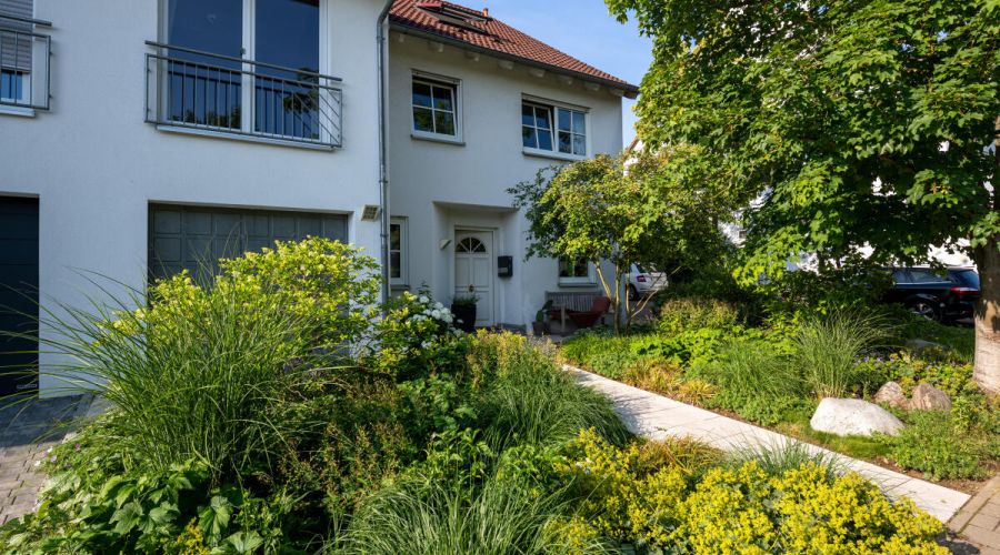 Üppig bepflanzter Vorgarten mit einem Weg, der zum Haus führt