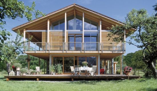 Modernes Holzhaus mit großen Fenstern und Garten