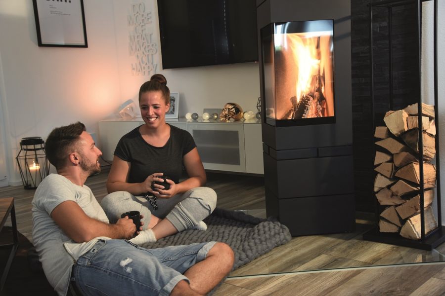 Paar sitzt verträumt vor dem Kamin