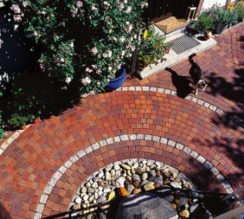 Terrasse aus Pflasterklinker in warmen Braun- und Ockertönen, fantasievoll in einem Kreis verlegt