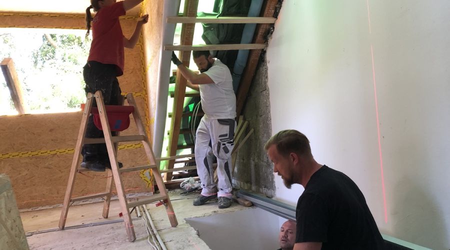 Verschiedene Handwerker arbeiten gleichzeitig im Dachgeschoss
