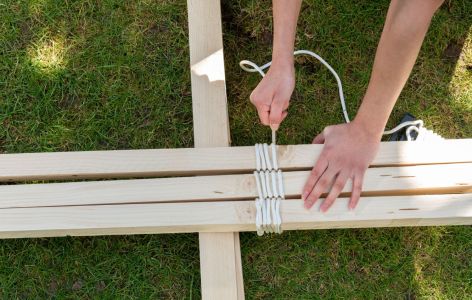 Hände knoten Holzleisten zusammen