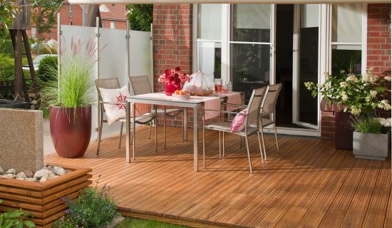 Holzterrasse mit Gartentisch und Stühlen