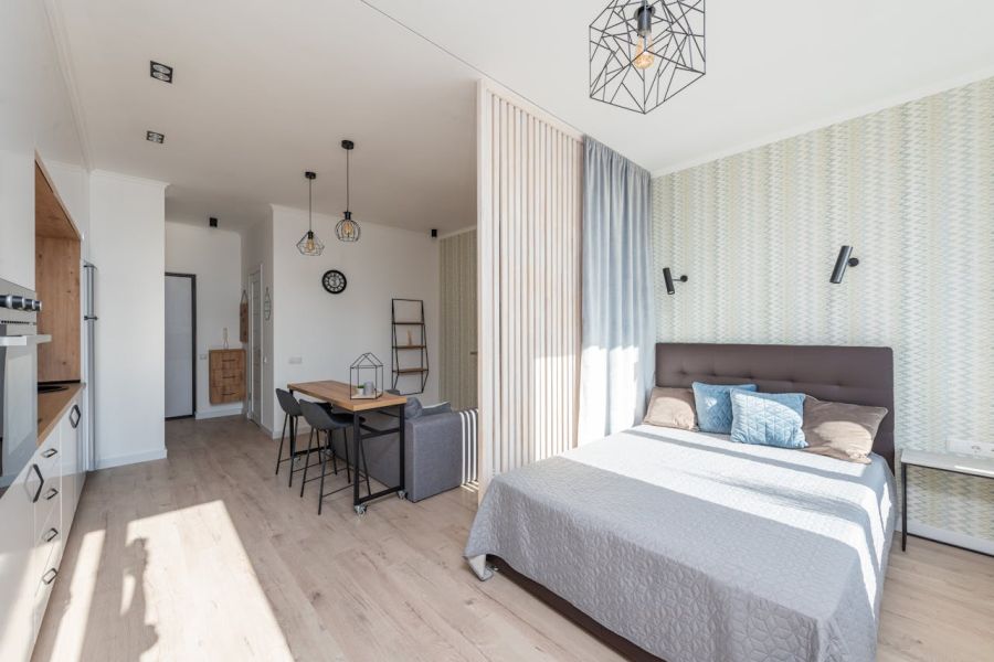 Dieses Schlafzimmer wurde mit einer Holzlamellenwand und einem Vorhang zum Wohnbereich abgegrenzt.