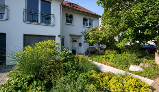 Üppig bepflanzter Vorgarten mit einem Weg, der zum Haus führt