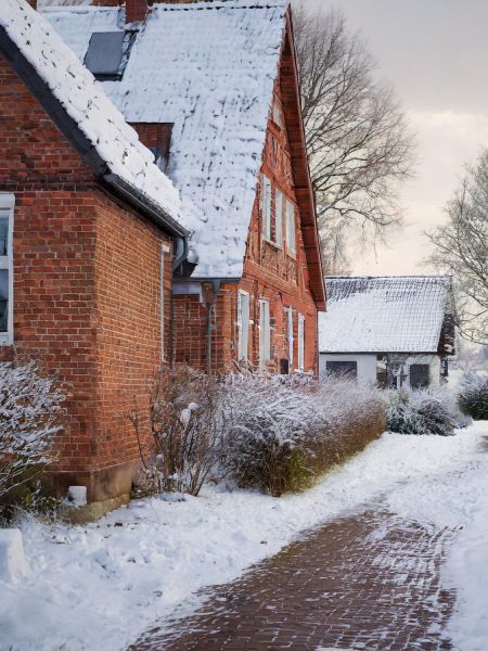 Verschneiter Weg zwischen zwei Grundstücken