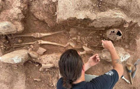 Archäologe gräbt Steingrab mit Skelett frei