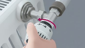 Eine Hand dreht das weiße Thermostatventil eines Heizkörpers auf die höchste Stufe 5. Ein roter Pfeil über dem Thermostat visualisiert die Drehbewegung gegen den Uhrzeigersinn.