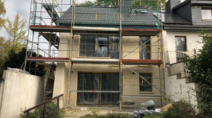 Frisch verputztes Haus, noch eingerüstet.