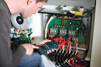 Mann misst Stromstärke der Solaranlage