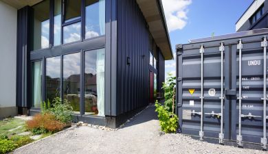Frontalansicht des Hauses, rechts steht der Container