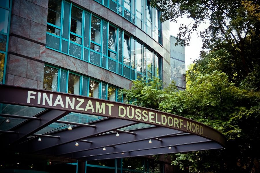 Gebäude mit der Aufschrift Finanzamt Düsseldorf-Nord und grünem Umfeld