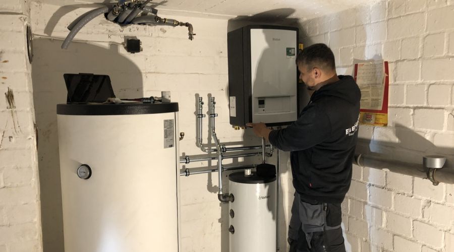 Handwerker baut Wärmepumpe innen ein.