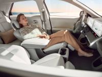 Frau macht ein Nickerchen, während ihr Elektroauto lädt.