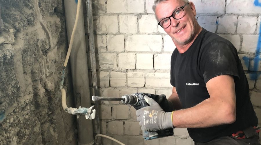 Handwerker mit schwerem Bohrgerät