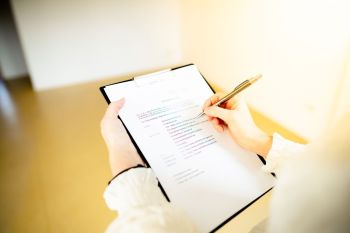 Frau macht schriftliche Eintragungen auf einem Block