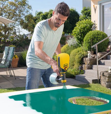 Mann besprüht Torwand mit Farbe