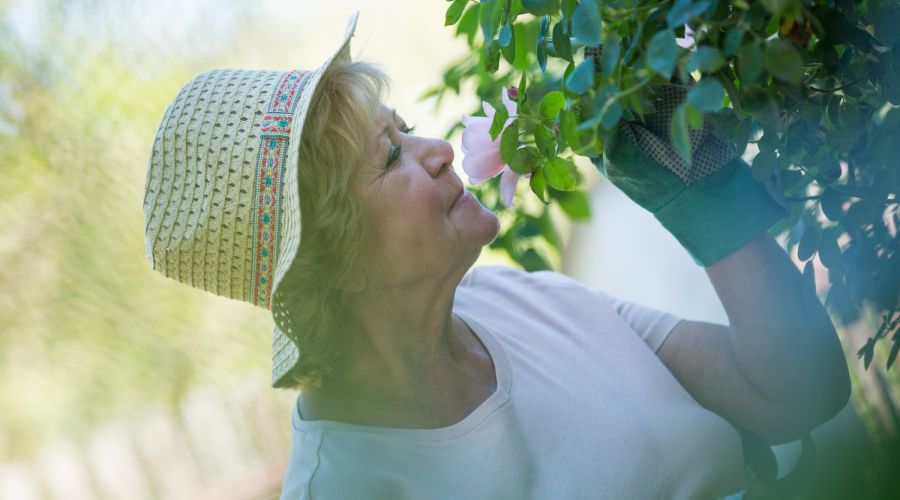 Frau riecht an Blüte