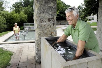 Mann hält die Arme in kühlendes Wasser