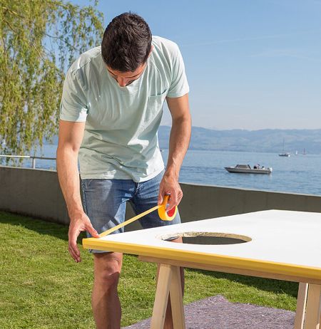 Mann verklebt die Seiten der Torwand mit Krepppapier