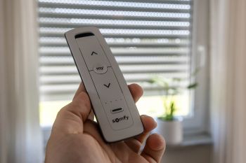 Hand hält Fernsteuerung für Rollläden