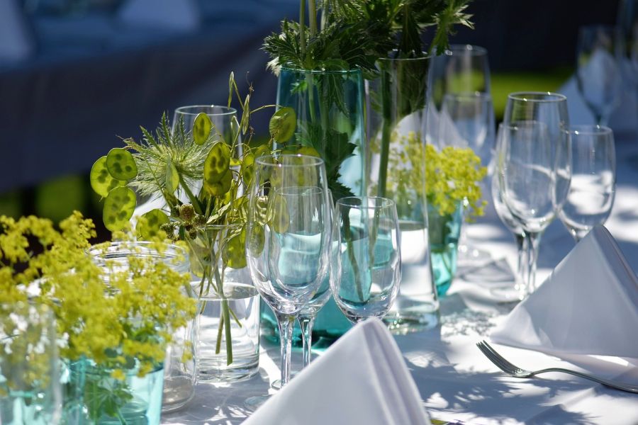 Festlich dekorierter Tisch im Freien mit verschiedenen Blüten und Blättern.