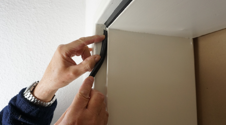 Eine Person drückt eine Fensterdichtung in die Nut