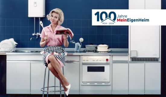 Frau sitzt vor Einbauküche