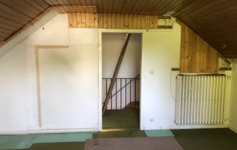 Düsteres Dachgeschoss mit Holzdielen an den Wänden