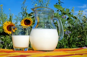 Glas und Kanne mit Milch