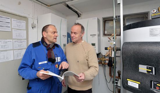 Mann mit Fachhandwerker im Heizungskeller