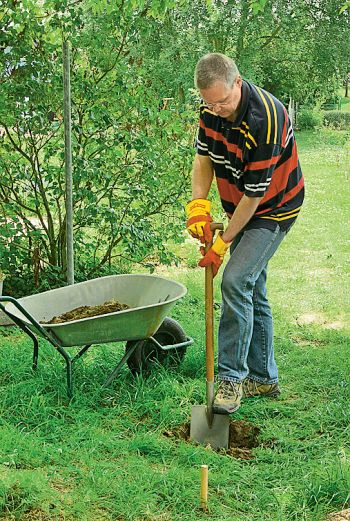 Mann hebt Fundament mit Spaten aus