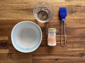 Schüssel mit Backpulver, Pinsel, Glas Wasser
