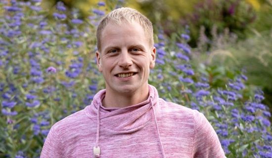 André Meyer vor blühender Bartblume im Hintergrund