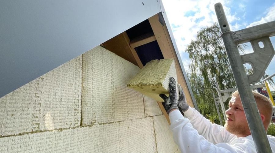 Handwerker bringt Dämmung unter den Giebel ein