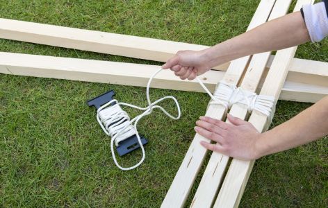 Hände knoten Holzleisten zusammen